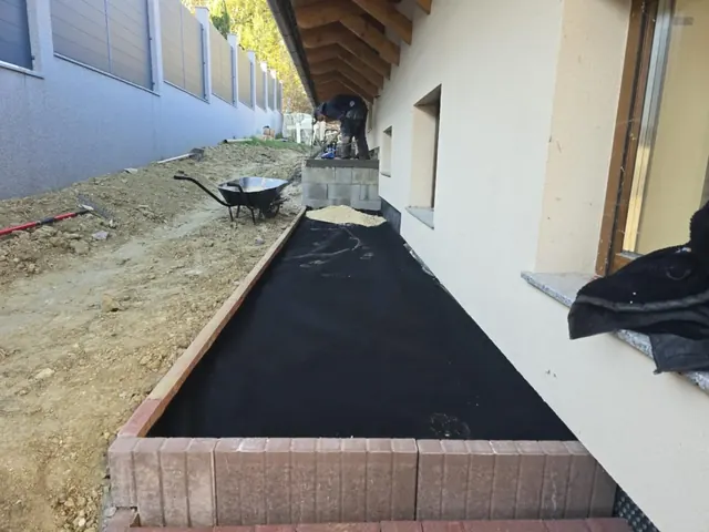 Geotextília leterítése és blokkszegély beépítése ház menti térkő járda alá